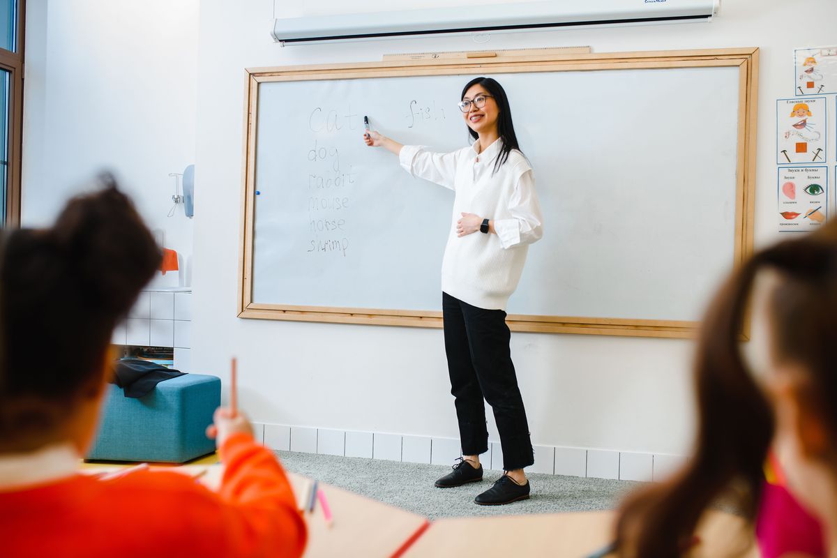 Teacher at a whiteboard with young students in an overseas classroom